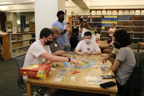 Students play a board game in the library during Game Night at ZSR