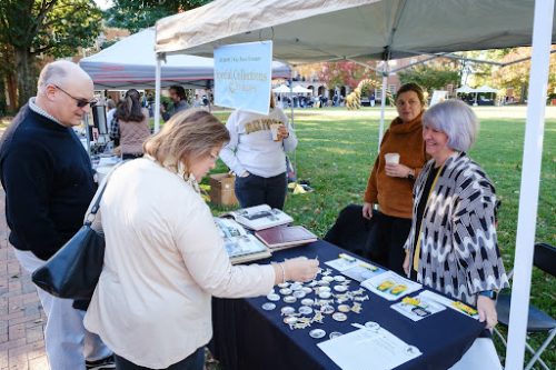 A pair representing ZSR's Special Collections and Archives speak with a pair of attendees for a tabling event on the quad