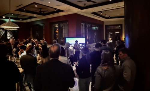 A full room of people looking at a speaker in front of a screen showing the ZSR Library.