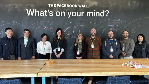 An image of Wake Forest friends in front of a blackboard at Meta that says "What's on your mind?"