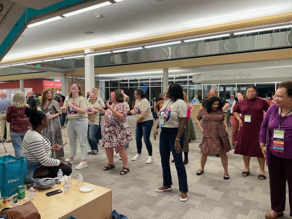 People lined up for a dance wearing matching shirts.