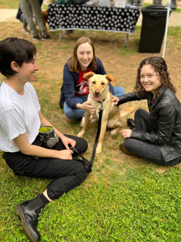 Smiling students and dog with Woof Forest as part of Wake the Library